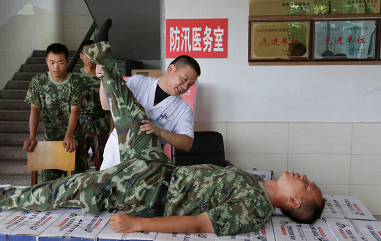 圖為醫(yī)療隊醫(yī)生在為8730部隊武警抗洪部隊官兵進行中醫(yī)正骨治療。